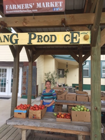 Farmer posing with produce at farmers market